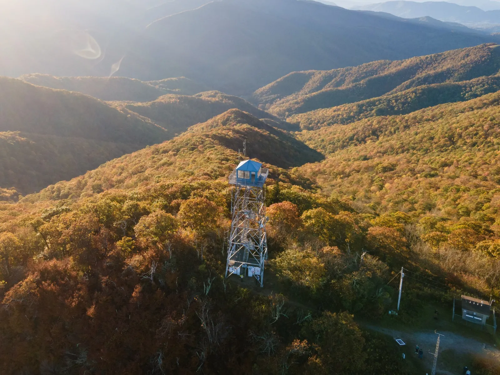 Historic fire lookout tower at the top of Fryingpan Mountain with the surrounding mountains visible through the steel framework