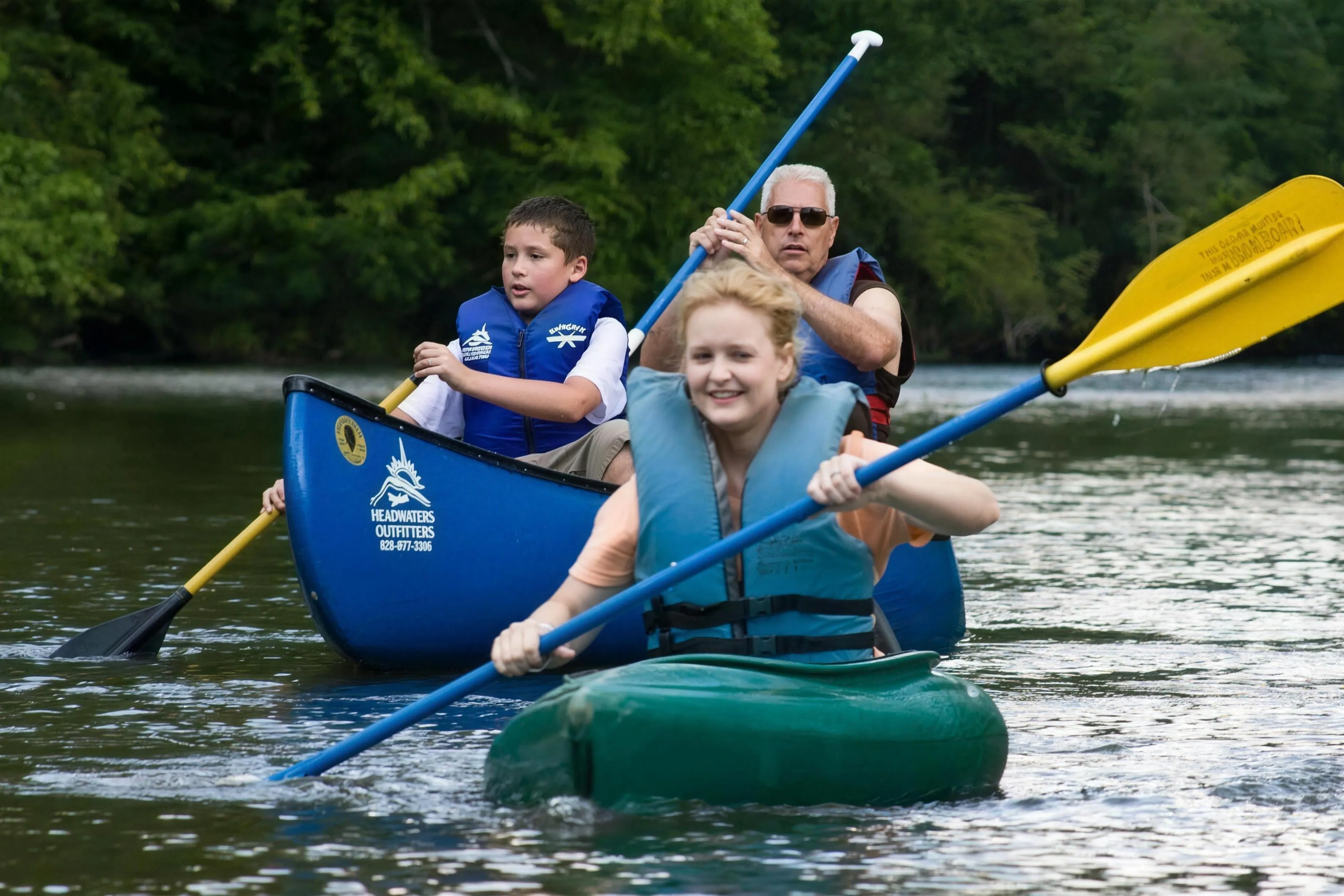 A family paddling Headwaters Outfitters canoes and kayaks on the gentle upper French Broad River near Rosman, North Carolina