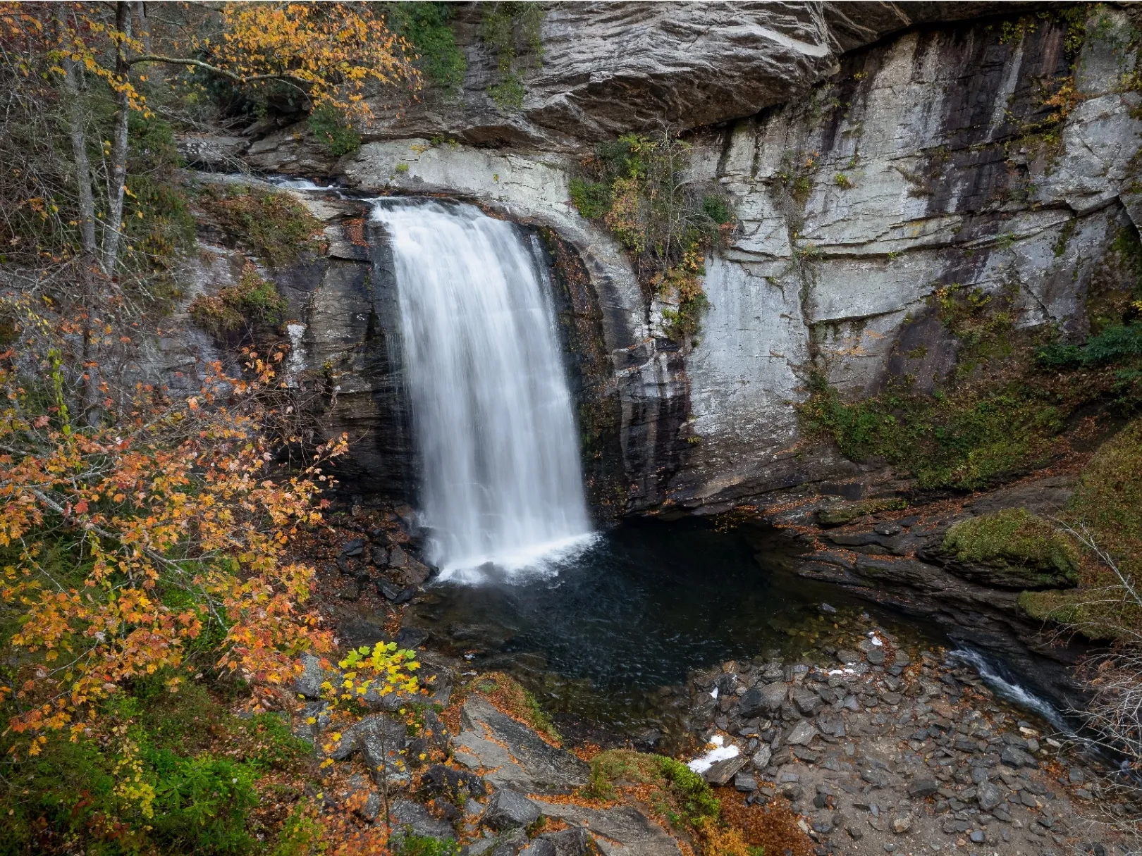 Looking Glass Falls cascading down a rock face with autumn foliage in Pisgah National Forest
